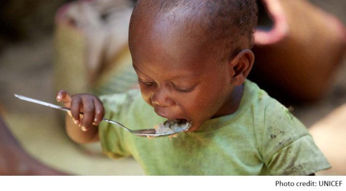 child eating spoon of rice