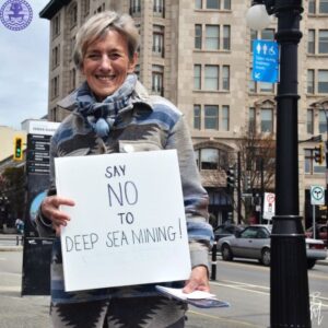 GRAN member Liz Dill holding a "say NO to deep sea mining sign"