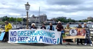GRANs holding a sign that says "No greenwashing no deep sea mining"