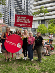GRANs holding up a sign with the GRAN logo and another sign that says "Grandmothers remember #FightForWhatCounts #EndAIDS"
