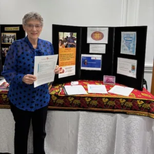 GRAN member standing beside info display about WASH for International Women's Day