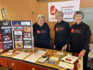 Three GRAN members stand behind info table.