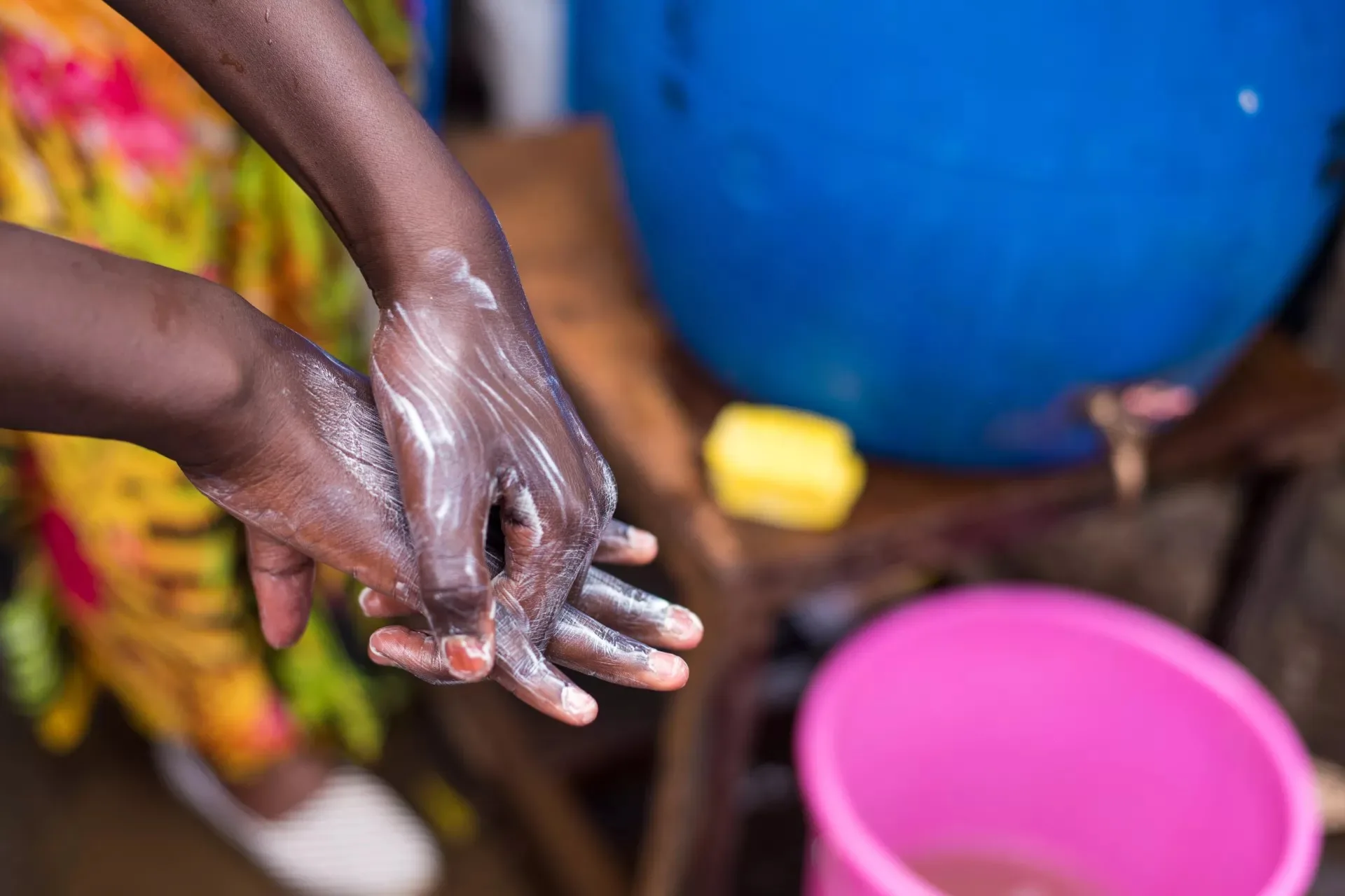 image of soapy hands above a water bucket