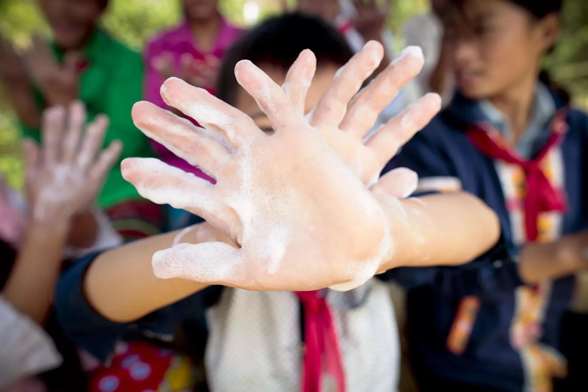 child holds up soapy hands